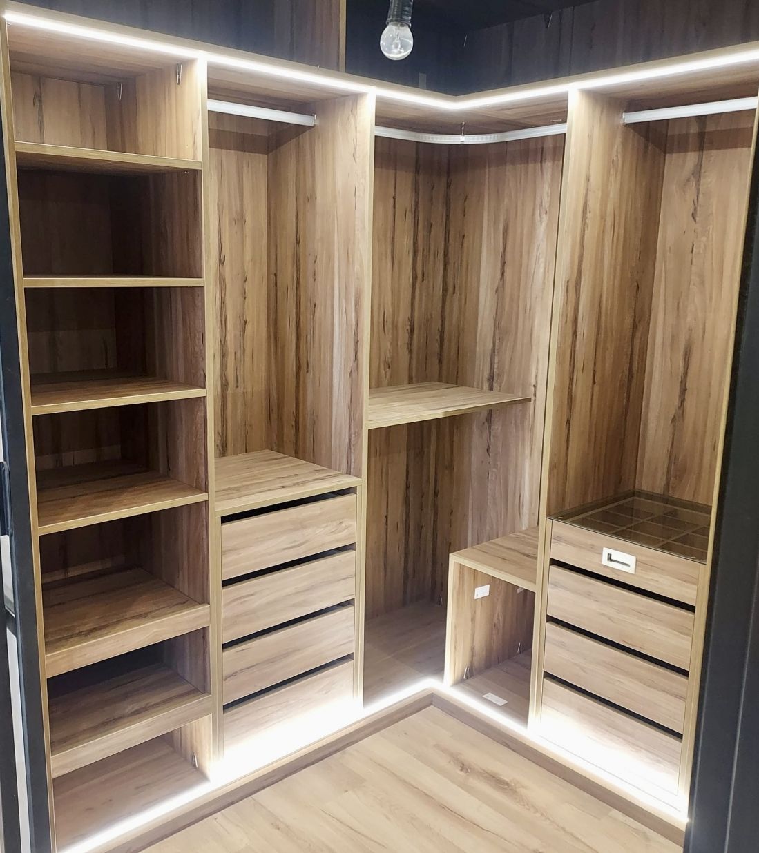 VE99 VESTIDOR EN L CON BALDAS EXTRAIBLES, BALDAS FIJAS, CAJONERAS Y CAJON DIVIDIDO CON TAPA DE CRISTAL. LUCES LED SUPERIORES E INFERIORES