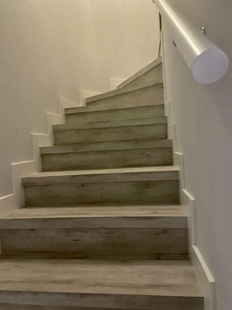 MU143 ESCALERAS EN SUELO QUICK STEP  REMATADAS CON RODAPIE LACADO BLANCO